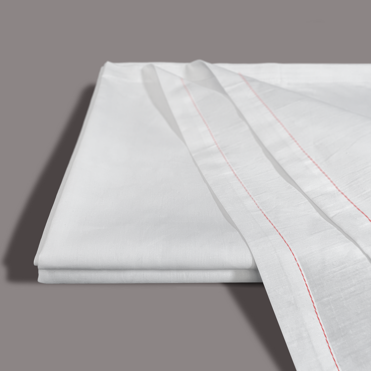 A smooth, folded Calderon Textiles T-180 Twin Drawsheet in white is shown with another sheet featuring thin, parallel red stitched lines, all set against a plain grey background.