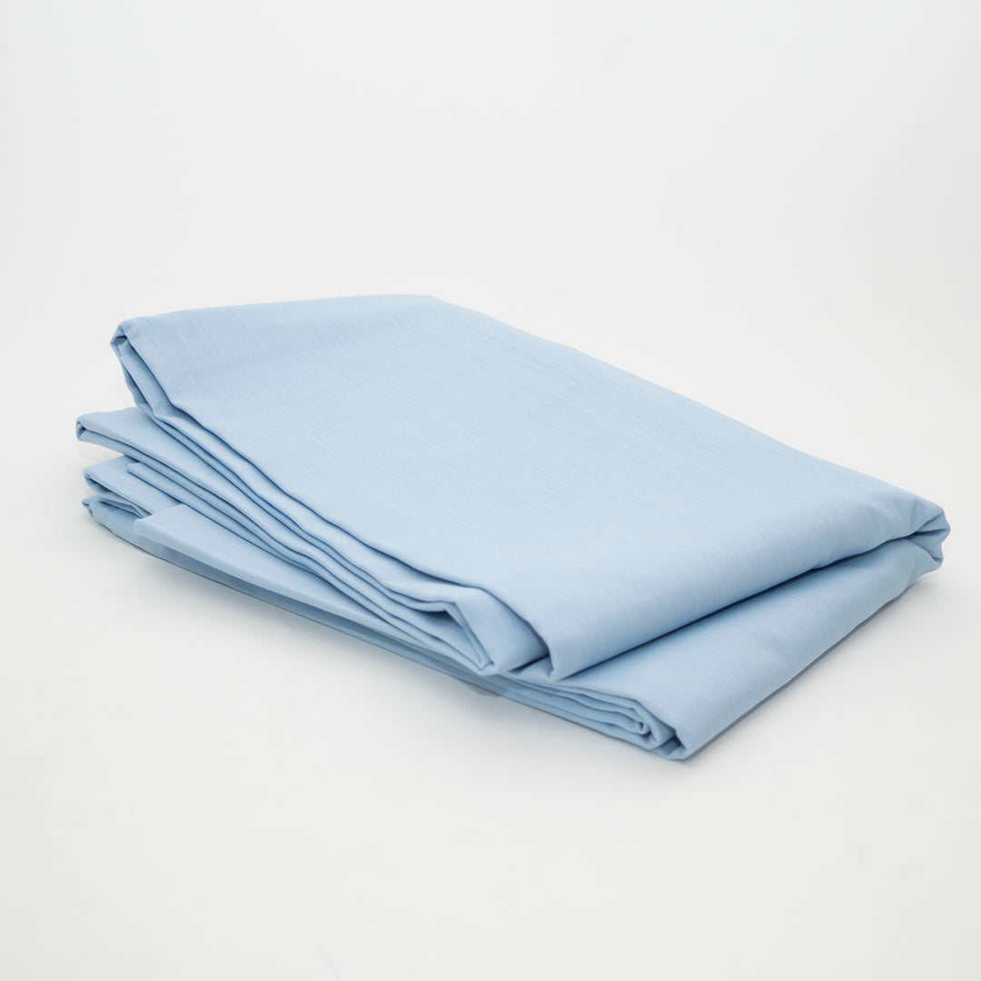 A neatly folded Calderon Textiles T-180 Sheets Twin Flat in light blue is displayed on a plain white background.