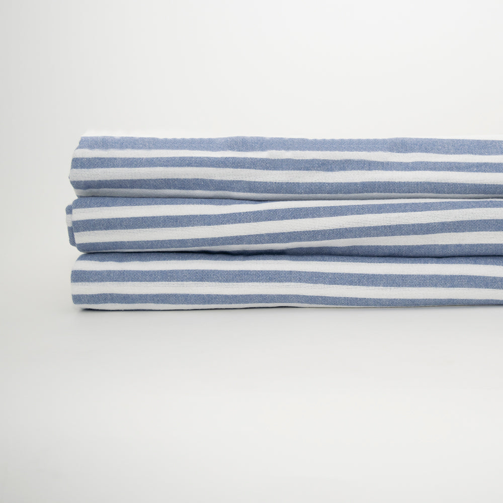 A neatly folded stack of Calderon Textiles Bath Blanket Bleached is displayed against a plain white background.
