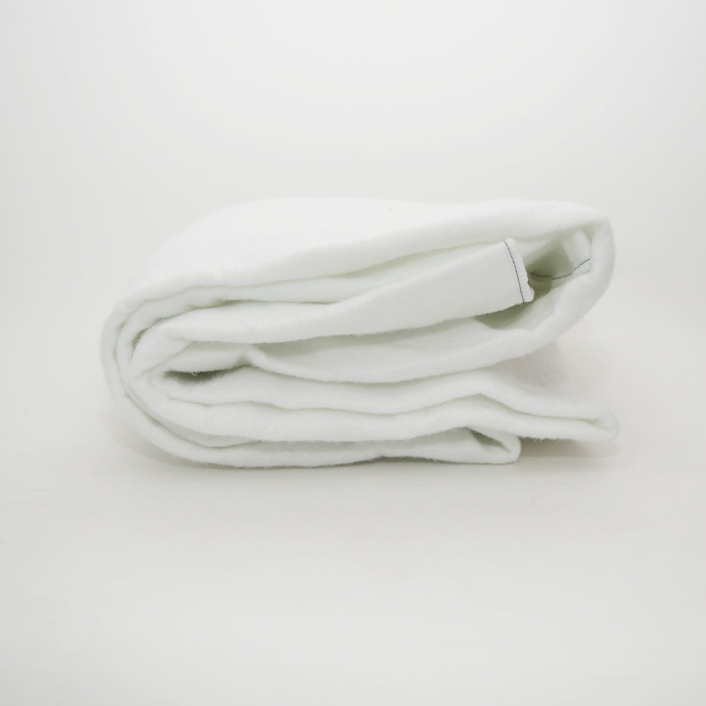 A neatly folded Calderon Textiles Mattress Pad Twin lies on a plain white surface, its soft and clean texture highlighted—ideal for enhancing mattress protection with quilted polyester felt.