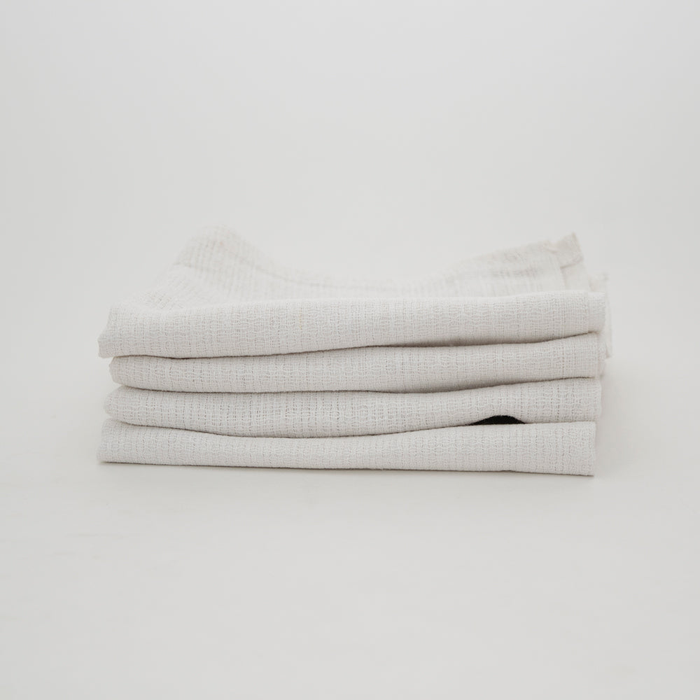 A neatly folded stack of Calderon Textiles Huck Towels, renowned for absorbency and low lint, is displayed against a plain white background.