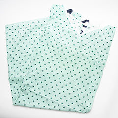Two folded Calderon Textiles Blended 10 XL Patient Gowns in light green, featuring small dark green dots, displayed on a white background.