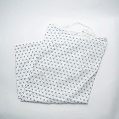 A folded Calderon Textiles Twil Patient Gown, white with a blue circular pattern and designed for IV/telemetry use, rests on a plain white background.