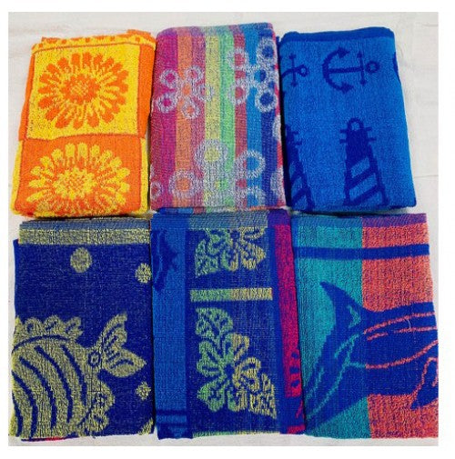 Six Ganesh Mills Promotional Beach Towels, each with a unique assorted design—flowers, anchors, stripes, dolphin, fish, and tropical patterns—are folded and arranged in two rows.