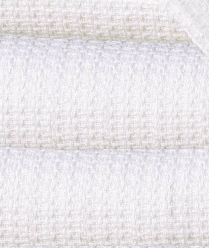 Close-up of neatly stacked KSE Baby Thermal Blankets, highlighting their soft, textured white fabric.