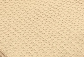 Close-up of the beige KSE Herringbone Spread Blanket, featuring a diamond-shaped waffle or honeycomb texture similar to classic hospital blankets.