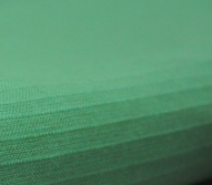 Close-up of a stack of green paper, resembling the textured edges and gaps often seen in KSE Ribcord Bedspread wholesale bedding products.