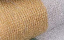 A close-up of Intralin's Center Stripe Hand & Bath Towels - 10s Towels reveals the soft, knitted texture and yellow-white stripes—ideal for wholesale buyers seeking quality and stylish hand towels.