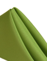 A close-up of a neatly folded, light green MagicSpun napkin by Ganesh Mills against a white background—perfect for bulk event use or restaurants seeking quality wholesale napkins.