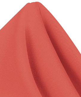 A close-up of a coral MagicSpun polyester napkin by Ganesh Mills, neatly folded to form a pointed peak against a plain background.