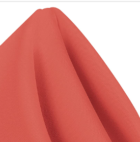 A close-up of a folded red MagicSpun napkin by Ganesh Mills, featuring smooth polyester fabric and a vibrant peak—perfect for bulk event needs.