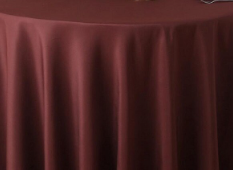 The Oxford Round Table Linen by Ganesh Mills is a multicolor polyester tablecloth that drapes smoothly to the floor over a round table.