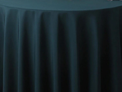 The Oxford Round Table Linen - Multicolor by Ganesh Mills is a high-quality, dark green polyester tablecloth with soft vertical folds and floor-length coverage—ideal for elegant round table settings.