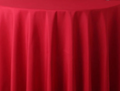 The Ganesh Mills Oxford Round Table Linen - Multicolor elegantly drapes over a round table, its fabric falling in soft folds for a stylish look.