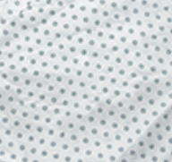 The Twil Patient Gown by Calderon Textiles features white fabric with small blue polka dots, available in bariatric sizes. Slightly wrinkled for a textured look, its designed for easy IV and telemetry access.