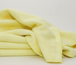 The Calderon Textiles Microfiber Cleaning Cloth, shown folded in yellow against a white background, provides exceptional absorbency and helps reduce laundering costs.