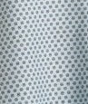 Close-up of Calderon Textiles Exam Patient Gown in white, featuring a geometric pattern of small gray stars and circles. This gown is ideal for IV and telemetry use, offering both style and practicality for bariatric patients.