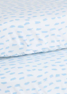 Close-up of KSE Knitted Bassinet and Crib Sheets, showcasing a pattern of irregular, light blue brushstroke-like shapes on white fabric.