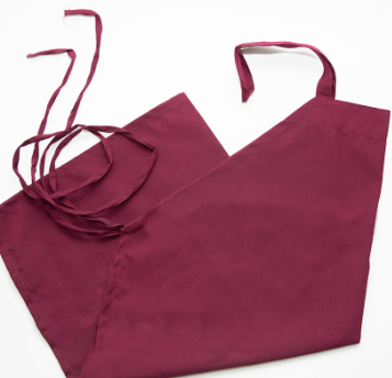 A maroon Prisma Bib Apron by Calderon Textiles, made of polyester and measuring 30 x 34 inches with long neck and waist ties, is laid flat on a white surface.