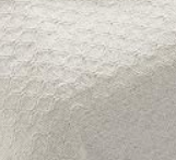 Close-up of the Intralin Newport Snag Free Blanket, a textured white cotton bedspread with a repeating circular or scalloped pattern.