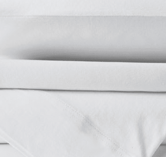 A close-up of neatly folded KSE Knitted Spandex Sheets stacked on top of each other.