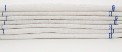 A stack of Calderon Textiles Kitchen towels with blue-edged stitching and a herringbone weave is displayed against a plain white background.
