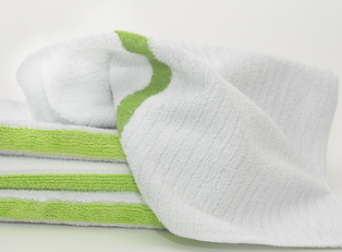 A close-up of Calderon Textiles Microfiber Bar Ribbed towels, neatly folded with green edge stripes on a light surface, resembling premium cleaning cloths.