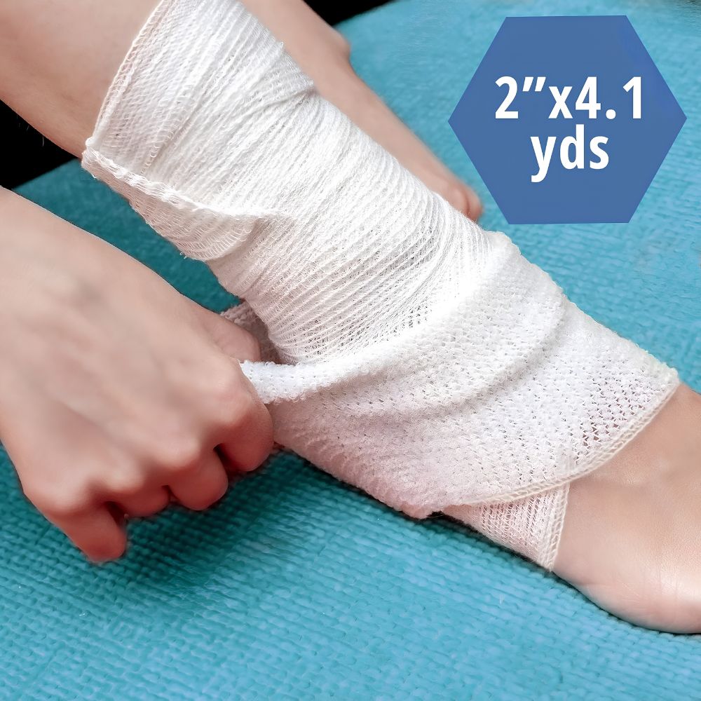 A person wraps a Shield Line MedPride Conforming Stretch Gauze Bandage Roll, 2 x 4.1 yds sterile, around their ankle and foot on a blue surface, showing its use in wound care.