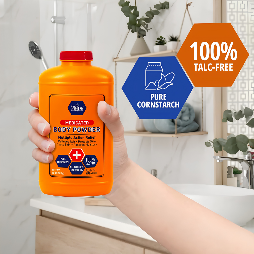 A hand holds a bright orange Shield Line MedPride Medicated Body Powder with Zinc Oxide, Talc-Free Cornstarch, and Seal (10 oz). A graphic shows 100% TALC-FREE and PURE CORNSTARCH. The sink, mirror, and plant are blurred in the background.