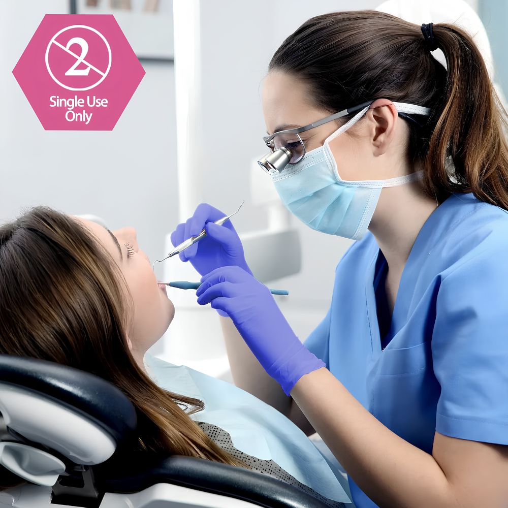 A dentist wearing a mask and Shield Line MedPride Nitrile Exam Gloves 4 Mil Thick (Non-Latex, Non-Sterile, Powder Free) examines a patient’s teeth in a dental office. A “Single Use Only” symbol appears in the upper left corner.