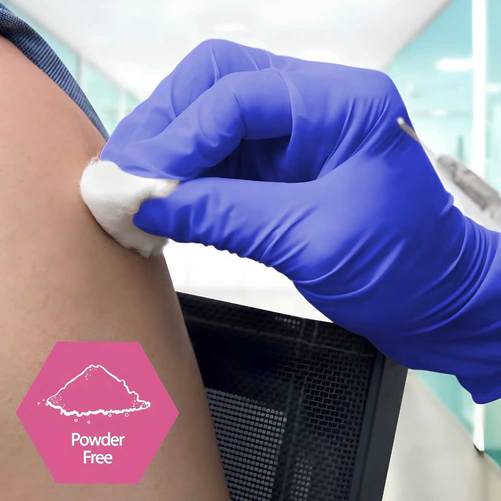 A gloved hand in Shield Line MedPride Nitrile Exam Gloves 4 Mil Thick (Non-Latex) cleans a person’s upper arm with a cotton ball before injection. A pink hexagon with a powder icon and “Powder Free” appears at the lower left corner.