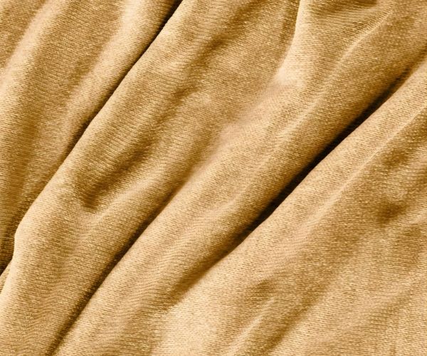 Close-up of soft, beige chenille fabric with gentle folds and a subtle sheen, similar to the WestPoint Home Vellux Renew Chenille Blanket—perfect for cozy, durable comfort in hospitality settings.
