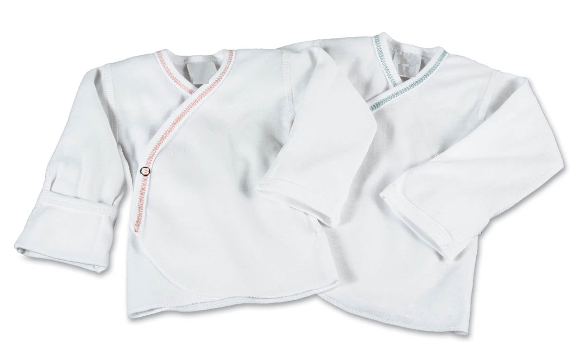 Two KSE Slip-Over Baby Shirts (short sleeve) for 3-month-olds, in white cotton with side snap closures; one trimmed in light pink, the other in light blue. Both shirts are laid flat and overlapping on a white background.