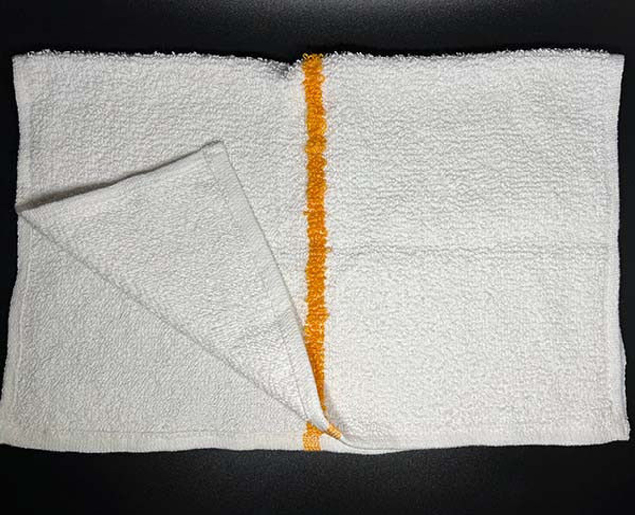 A white rectangular Ganesh Mills dishcloth from the Oxford Cleaning Towels & Bar Mops line, featuring a single vertical orange stripe, lies on a dark surface with one corner folded to show its texture and underside.