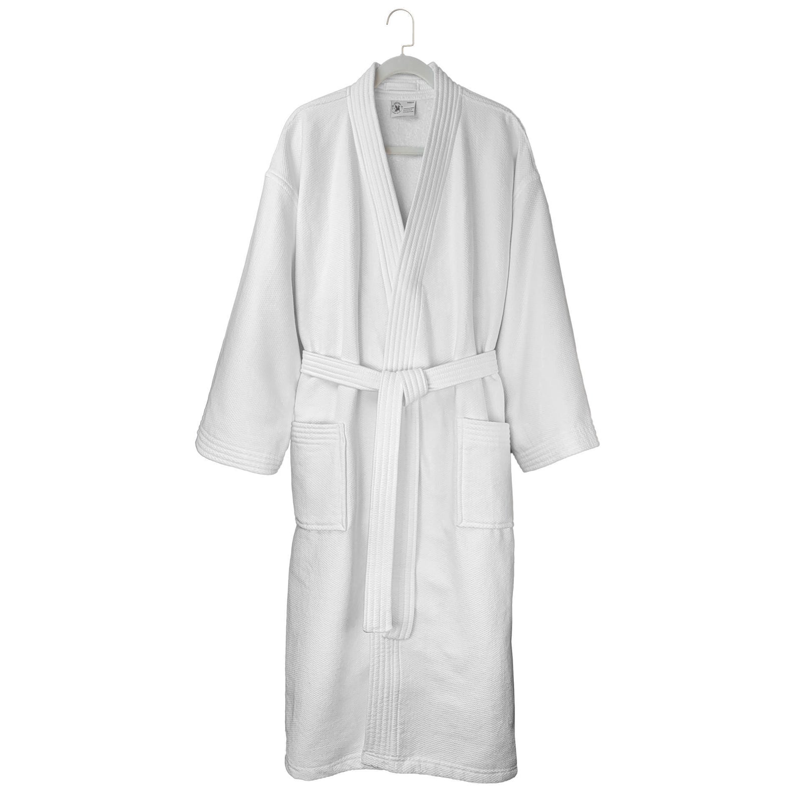 The Ganesh Mills Oxford Double Gauze Bathrobe in white with white piping features long sleeves, two front pockets, and a matching belt, hanging on a white hanger against a plain background.