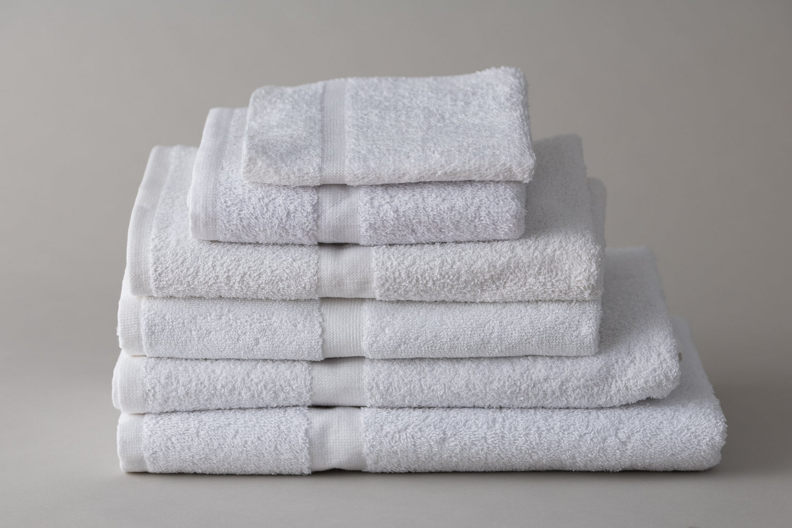 A neatly stacked set of Thomaston Mills Healthcare Items - T-180 Jade Green towels in various sizes, arranged from largest to smallest, displayed against a plain light gray background.