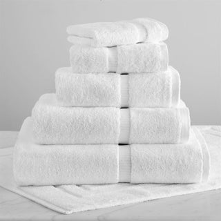 A pyramid stack of 1Concier Hand Towel 100% Cotton in white, each with a ribbed dobby border, is arranged on a white surface with one towel folded underneath.