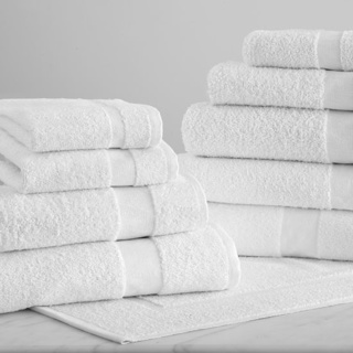 Stacks of neatly folded 1Concier Wash Cloths (88% cotton/12% poly) arranged on a flat surface against a simple, neutral background—ideal for elevating any guest spa experience.