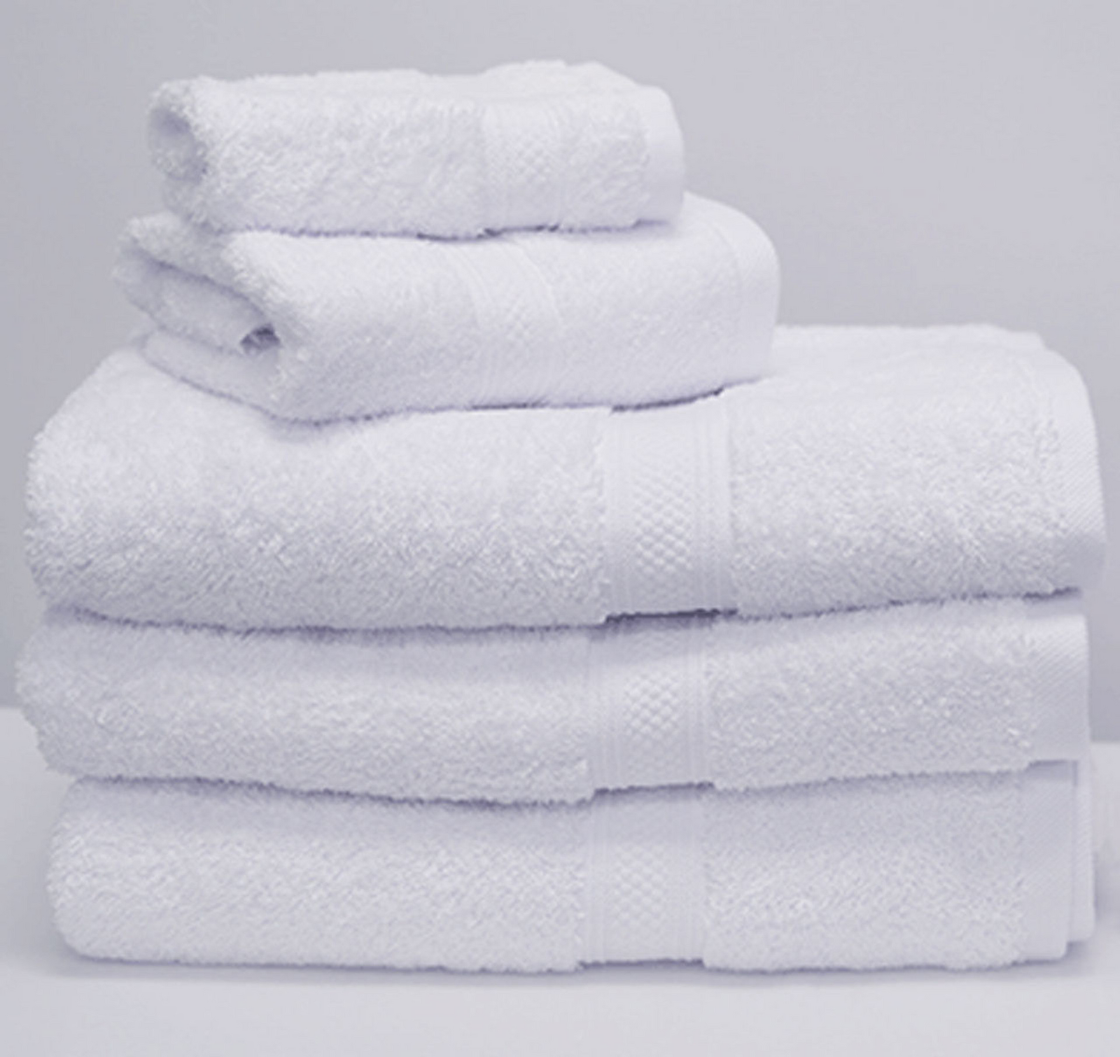 A neatly stacked set of 1Concier Bath Sheet Silver Terry 100% Cotton towels in various sizes, arranged from largest to smallest against a white background—ideal for enhancing your luxury bedding ensemble.