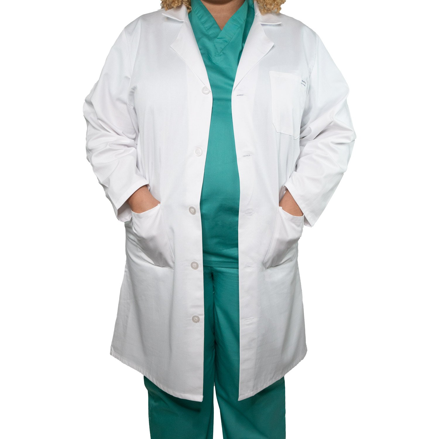 A person wears WestPoint Home's Martex Health Lab Coat over green scrubs, hands in pockets and facing forward. Cropped at neck and knees, the plain white background highlights the antimicrobial coat’s clean design.