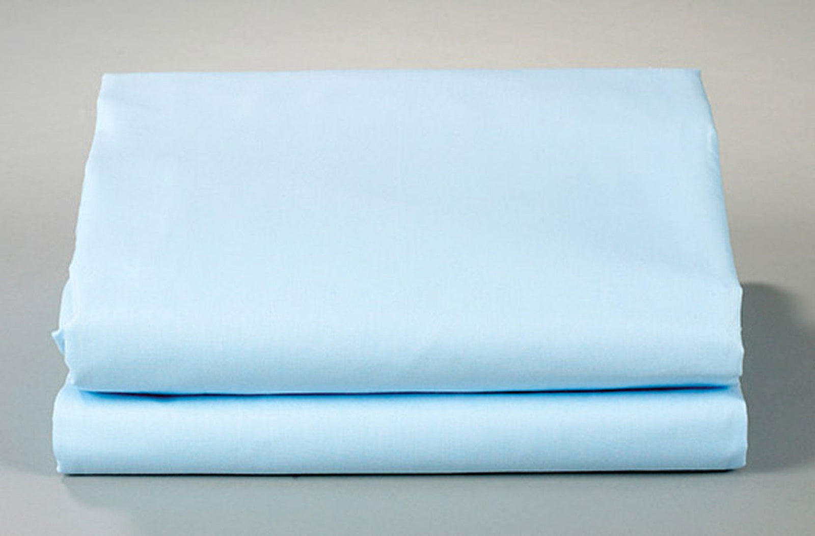 A neatly folded light blue Thomaston Mills Flat Sheet - Single Pick Percale is displayed on a flat surface against a plain, neutral background.