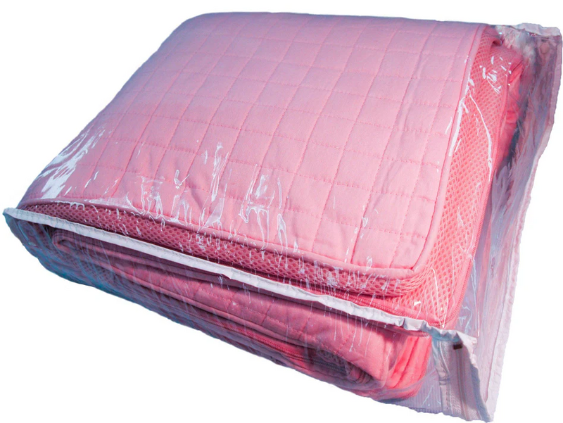Pink quilted cover in a clear plastic bag on a white background