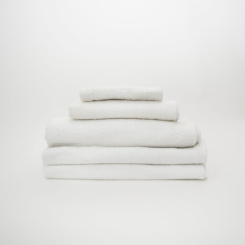 A stack of four neatly folded Calderon Textiles Sweet 16 Wash Cloths in white cotton is arranged on a plain white background.