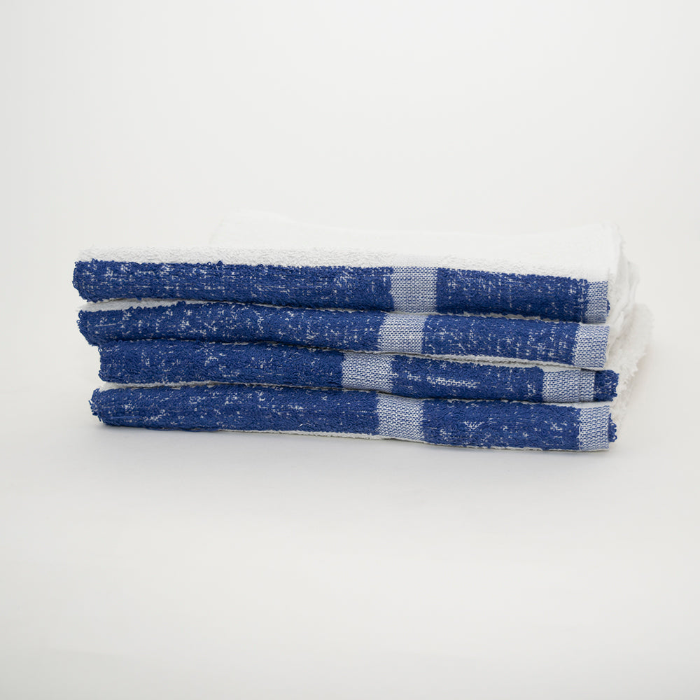 Four International Pool Towels by Calderon Textiles, made of 100% cotton with blue and white stripes, are stacked neatly on a white surface against a plain background.