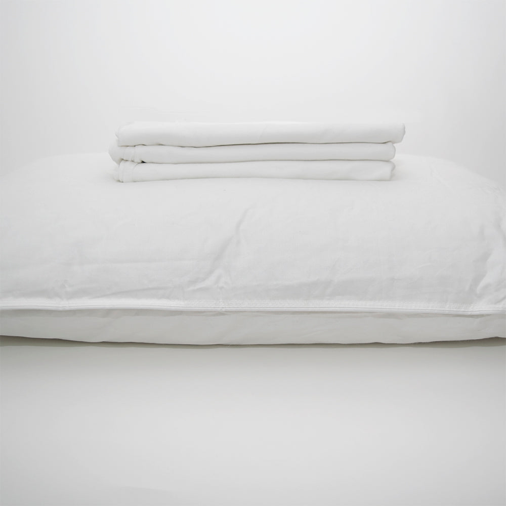 A neatly folded Calderon Textiles Knitted Pillowcase - Envelope Style is stacked atop another pillowcase, both set against a plain white background.