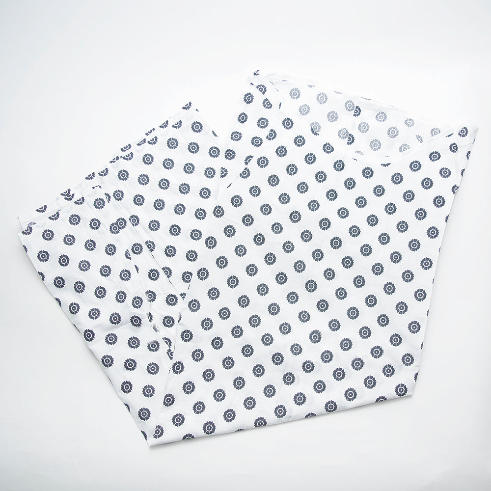 Two pieces of white fabric with small, circular blue floral designs from the Economy Patient Gown by Calderon Textiles are laid flat on a white background, perfect for crafting a comfortable and stylish patient gown.