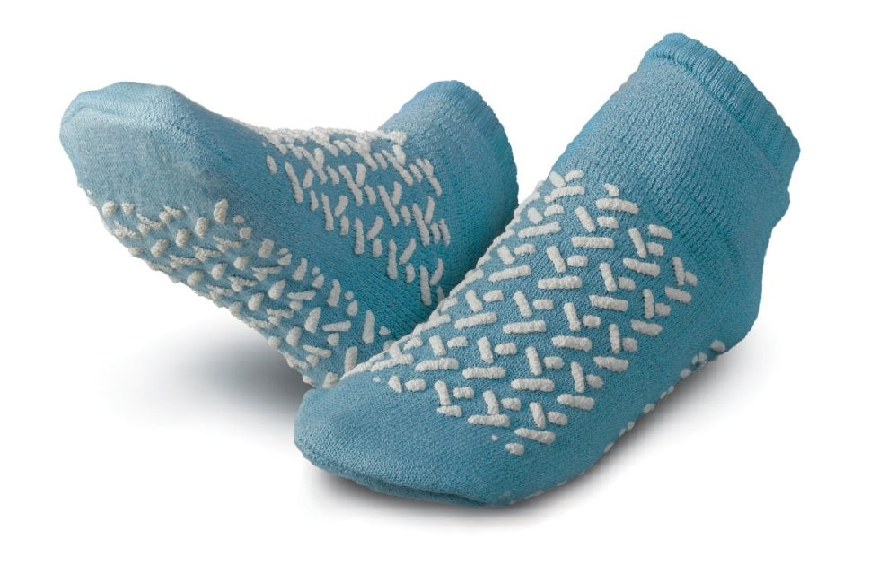 A pair of KSE Double-Tread Slipper Socks in blue with white nonskid patterns on the soles, shown against a white background.